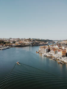 杜罗河畔波尔图老城全景，彩色建筑沿岸错落，小船划破水面