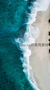 海浪轻抚沙滩的航拍特写：蓝绿海水与洁白沙岸的柔美边界