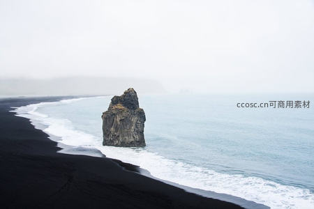 冰岛维克黑沙滩旁海蚀柱孤耸雾中，浪花拍岸，苍茫静谧的极地海岸线