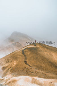 雾中火山脊步道上的孤独旅人航拍视角