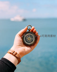 手持复古指南针凝望海面远方轮船微距特写