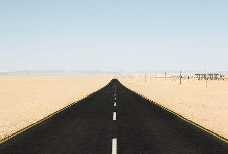 沙漠中笔直延伸的柏油路通向远方地平线，两侧黄沙无垠，天空澄澈