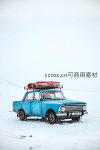 雪原中蓝色老式轿车载救生圈，荒凉旅途中的坚韧印记