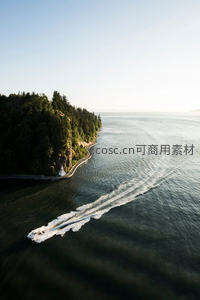 航拍快艇疾驰海岸线，白浪划破碧海森林崖岸