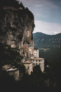 悬崖峭壁间嵌入的古老教堂与民居，绿意山谷衬托出险峻与信仰的交融