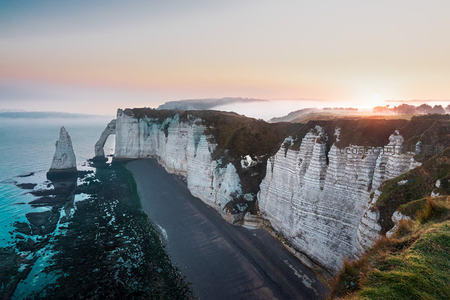 法国埃特勒塔象鼻山日出云海，白色 chalk悬崖与黑沙滩交相辉映