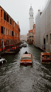 威尼斯雨雾中贡多拉穿行狭窄水巷