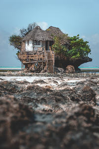 海蚀孤岩上的茅草小屋，热带海岸线独特民居