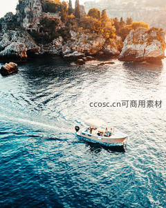 夕阳余晖中快艇驶过地中海悬崖海岸，波光粼粼如画