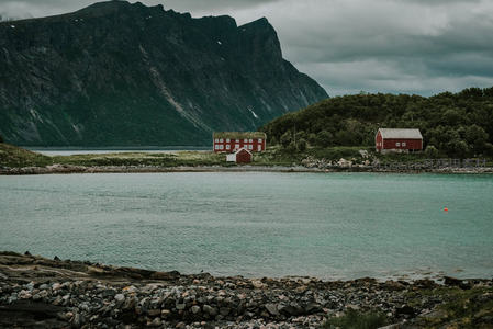 挪威峡湾畔红顶木屋静卧碧水边，青山环抱云雾缭绕