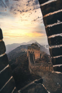 透过长城垛口远眺日落时分的金山岭长城蜿蜒山脊