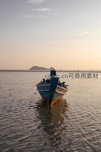 黄昏浅滩静泊小渔船，远山剪影映水波