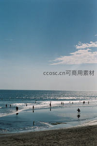 阳光沙滩上人群戏水，海天一色宁静悠远