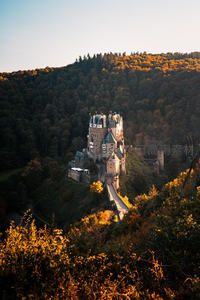 秋日森林中的古老城堡：夕阳映照下的欧洲中世纪要塞全景