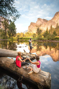 优胜美地河畔休憩时光，三人围坐原木共享清泉与壮丽花岗岩壁
