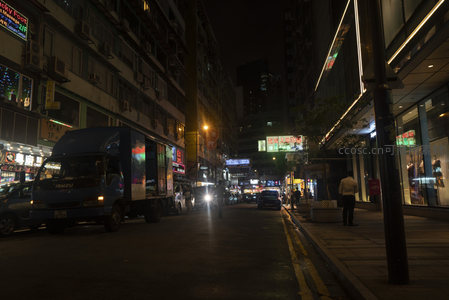 夜幕下香港街巷货车停靠霓虹闪烁的城市脉搏