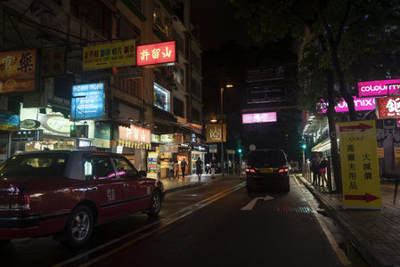 许留山招牌下红色出租车穿行霓虹林立的旺角夜街
