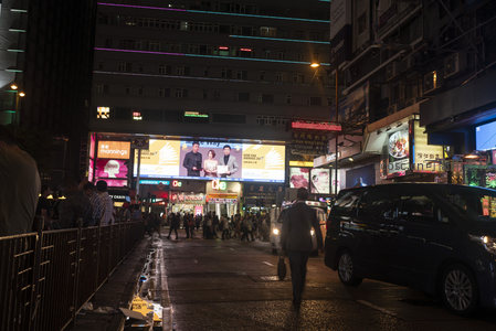 尖沙咀街角夜归人与流动车影的城市叙事