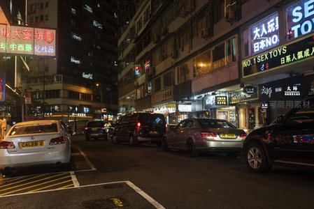 旺角夜间街巷，车流停驻，五光十色广告牌映照市井百态