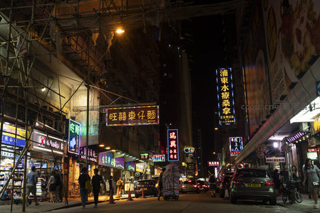 深水埗夜市窄巷，脚手架纵横，各色招牌林立，行人穿行其间