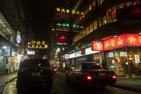 红黑车流掠过招牌长廊，香港夜街的动感与静谧并存