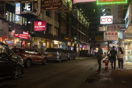 香港夜市霓虹灯下的繁华街景，行人车辆穿梭其间