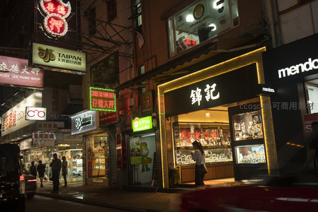 锦记珠宝店暖光橱窗前，霓虹与车影交织的街角瞬间