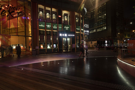 K11艺术购物中心外广场夜景，木质步道与品牌橱窗辉映