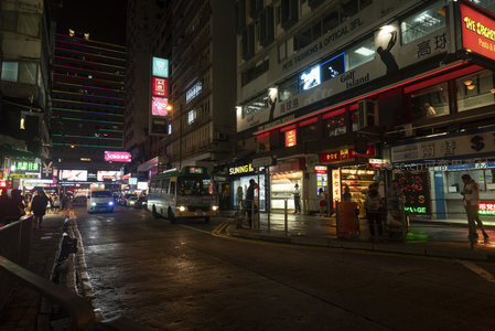雨后港岛街巷夜景，彩色LED幕墙与老店招牌交相辉映