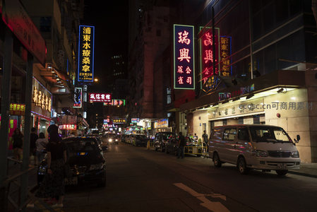 砵兰街夜色长廊，密集招牌与街边食客构成地道港味生活图景