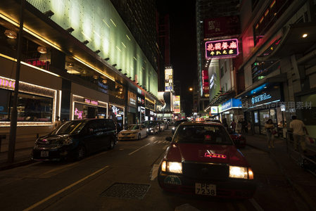 香港夜市霓虹街景，红色出租车穿行繁华商业街区