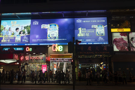 旺角街头夜市全景，大型广告屏播放奶粉广告与时尚影像