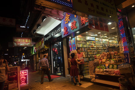 定制裁缝店旁药房琳琅满目，夜色中人来人往