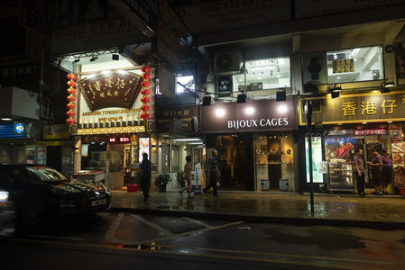 雨夜铜锣湾街角：黑车掠过老字号食肆与珠宝店