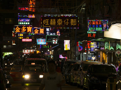 旺囍车仔面与金多宝招牌闪耀，出租车流穿行于霓虹密布的繁忙夜街