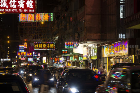 香港旺角夜市霓虹灯海，车流穿梭于密集招牌之间