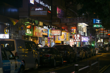 香港旺角夜市霓虹灯街景，车流穿梭于繁华商铺之间