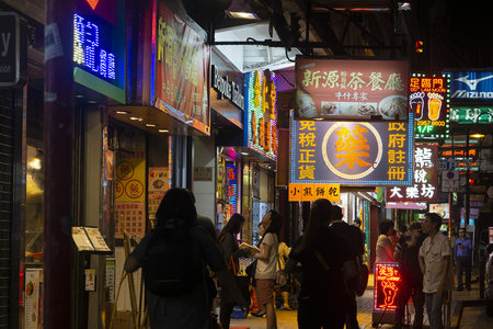 旺角深夜街景：行人背影与闪烁招牌构成动态都市画卷