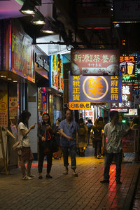 霓虹闪烁的香港夜市街景，行人穿梭于繁盛招牌之间