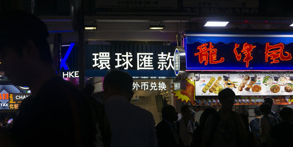 环球汇款与龙泽风小吃摊并置，夜市人潮剪影掠过