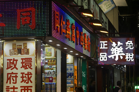 霓虹灯闪烁的香港街市夜景，繁体字招牌林立，充满市井烟火气