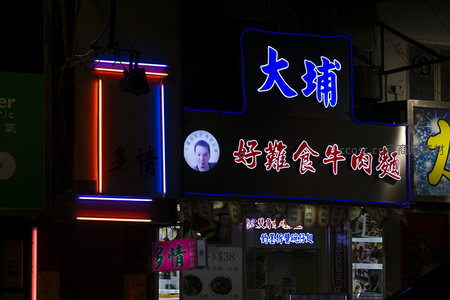 夜色中霓虹闪烁的‘大埔好雑食牛肉麵’招牌，蓝红光交映充满港式市井气息