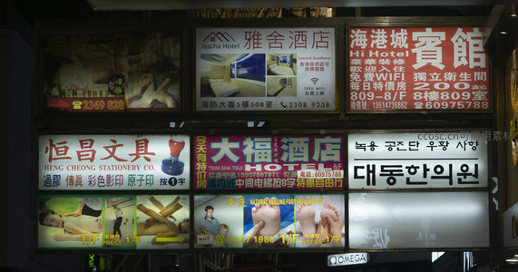 密集广告墙展现城市信息洪流：酒店、文具、足疗与韩语招牌共存