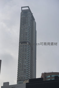 螺旋式超高层摩天大楼仰拍，玻璃幕墙反射阴云天空