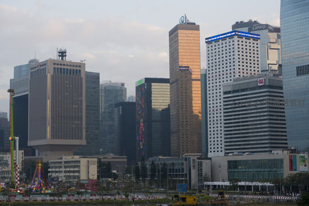 黄金余晖洒落CBD摩天楼群，玻璃幕墙反射暖色光辉