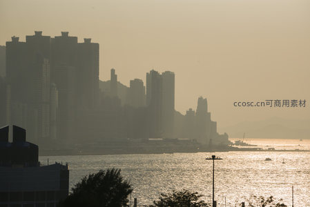 夕阳洒金维港水面，香港岛高层建筑群剪影如画