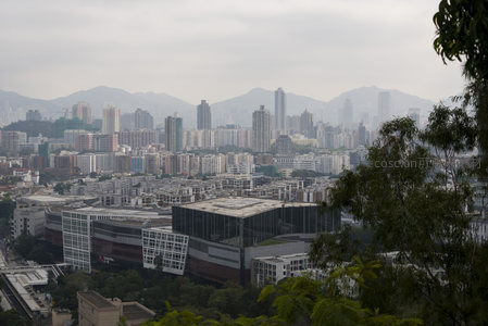 雾霭中的都市天际线，远山隐现，现代建筑群层叠错落
