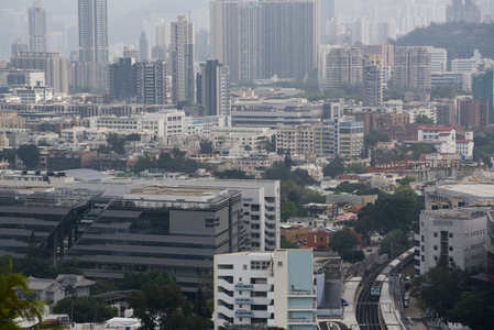 轨道交通穿行城市街区高楼与工业厂房交织景象