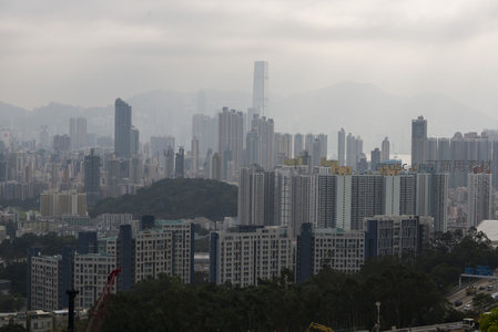 雾霭中的香港城市天际线，高楼林立与远山相映成趣