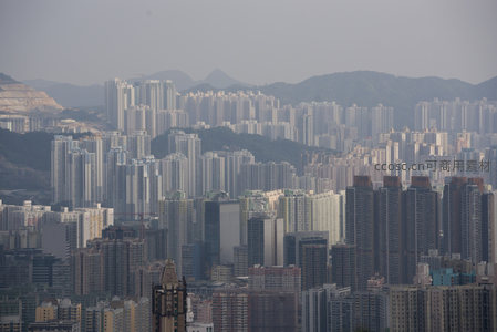 层叠楼宇延伸至山脚，香港典型高密度居住区航拍影像